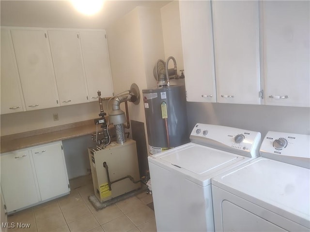 washroom featuring cabinets, light tile patterned floors, water heater, and washing machine and clothes dryer