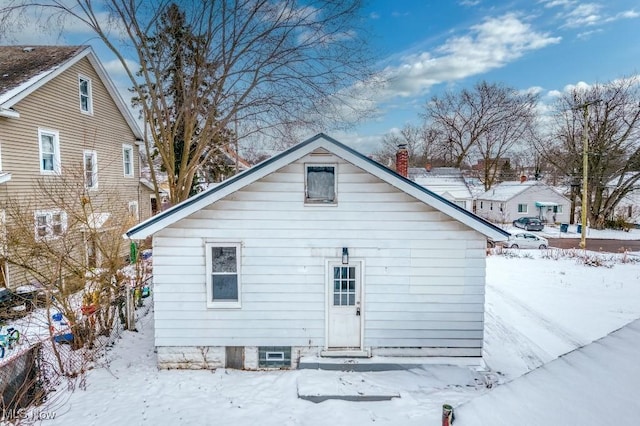 view of snow covered back of property