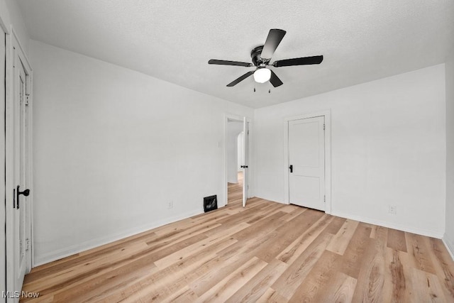 unfurnished bedroom with ceiling fan, a textured ceiling, and light wood-type flooring