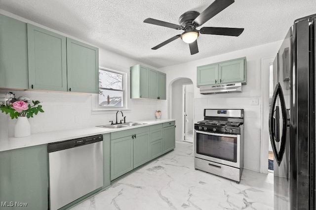 kitchen with stainless steel appliances, sink, green cabinets, and a textured ceiling