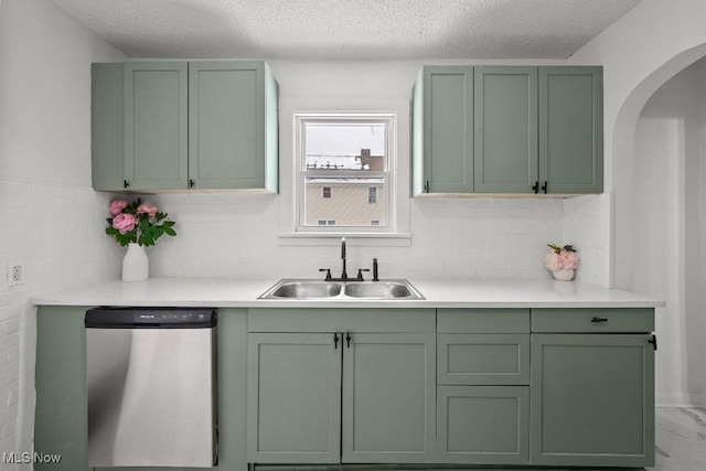 kitchen with sink, stainless steel dishwasher, decorative backsplash, and green cabinetry