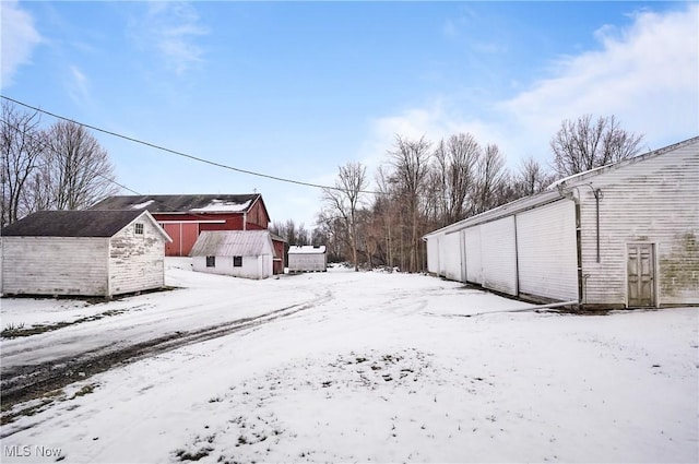 yard layered in snow featuring a storage unit