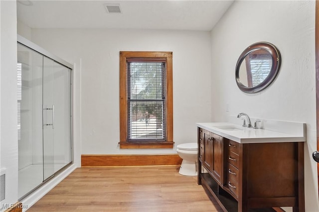 bathroom featuring toilet, hardwood / wood-style floors, vanity, and walk in shower