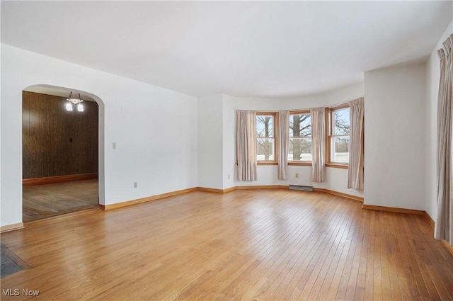 unfurnished room featuring a baseboard radiator and light wood-type flooring