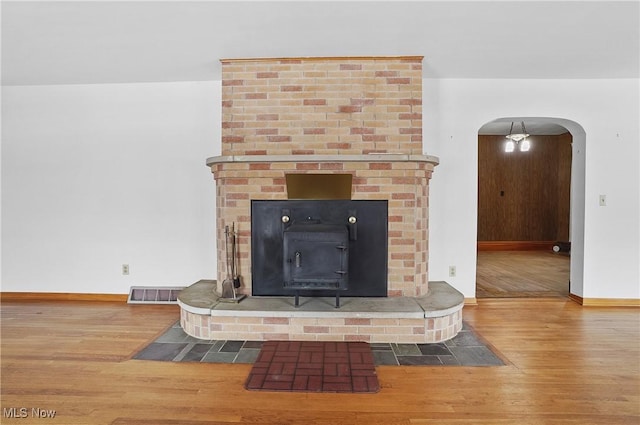 interior details featuring a wood stove and hardwood / wood-style floors