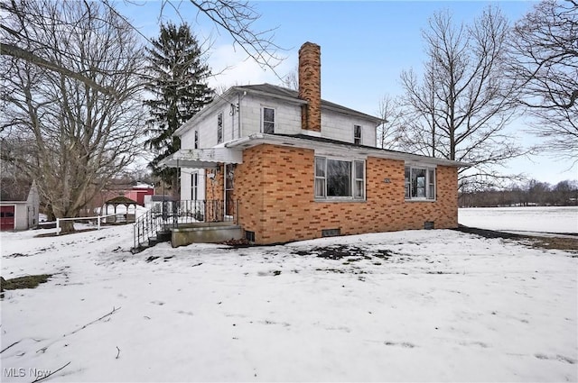 view of snow covered rear of property