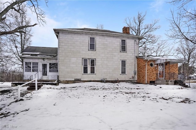 view of snow covered rear of property