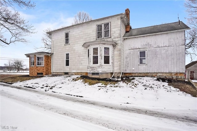 view of snow covered rear of property