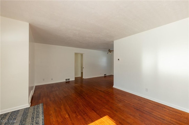 unfurnished room with dark wood-type flooring and a textured ceiling