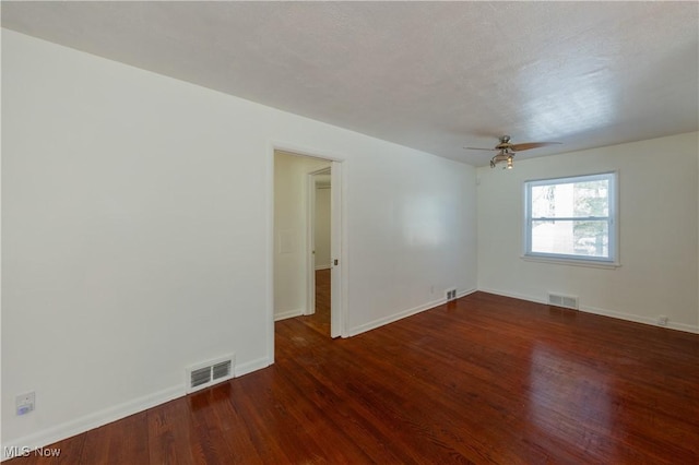 empty room featuring dark wood-type flooring and ceiling fan