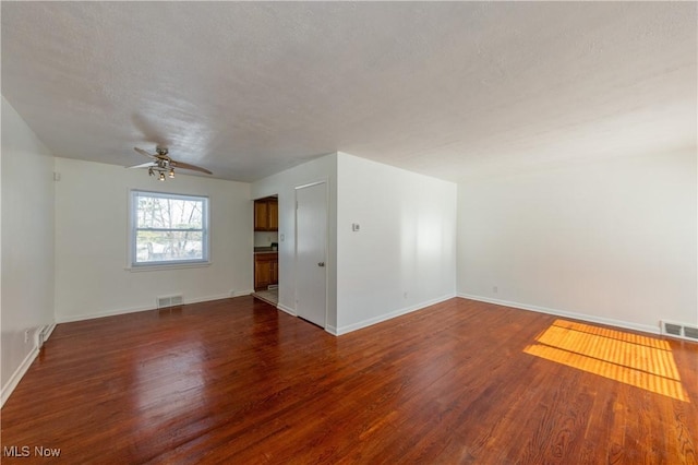 spare room with ceiling fan, dark hardwood / wood-style flooring, and a textured ceiling