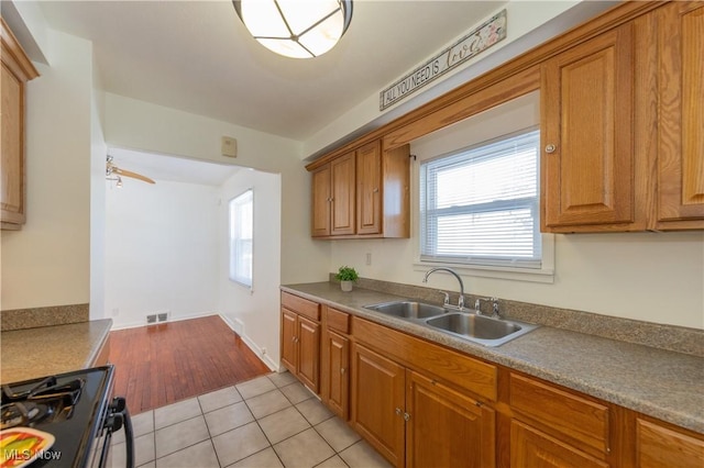 kitchen with ceiling fan, range, sink, and light tile patterned floors