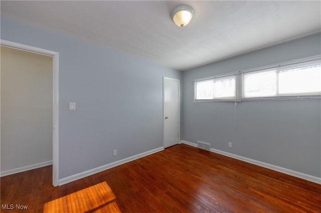 empty room with dark wood-type flooring