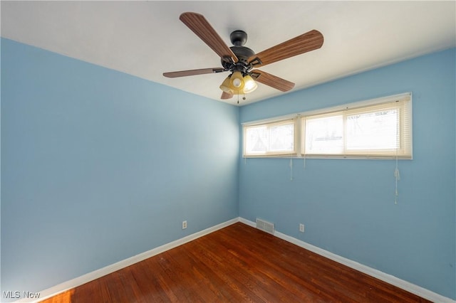 empty room with dark hardwood / wood-style floors and ceiling fan