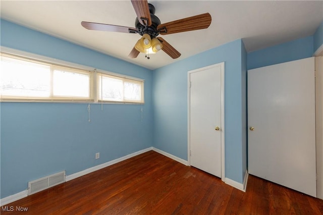 unfurnished bedroom with ceiling fan and dark hardwood / wood-style flooring