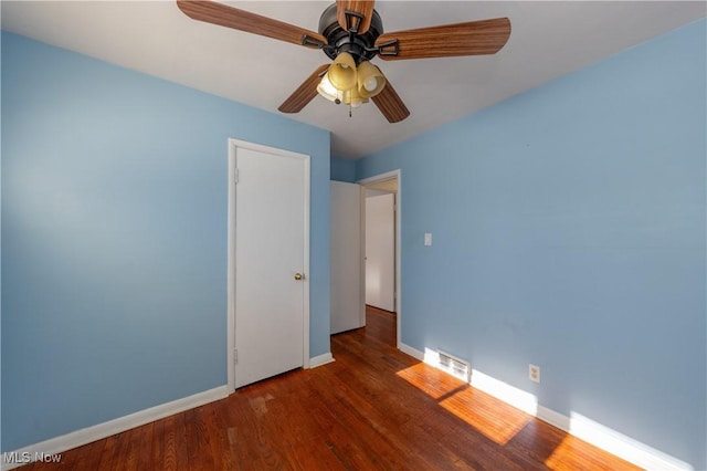 unfurnished bedroom with dark hardwood / wood-style floors and ceiling fan