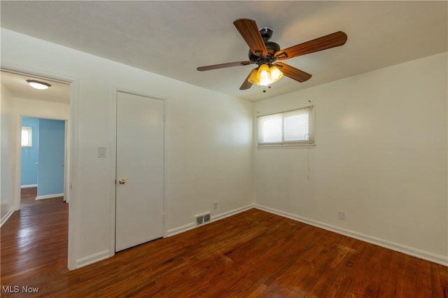 unfurnished bedroom featuring dark wood-type flooring and ceiling fan