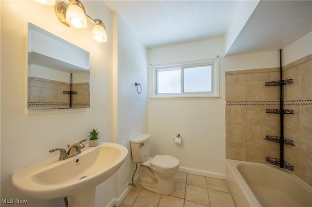 full bathroom with tiled shower / bath, toilet, tile patterned flooring, and sink