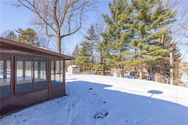 snowy yard featuring a sunroom