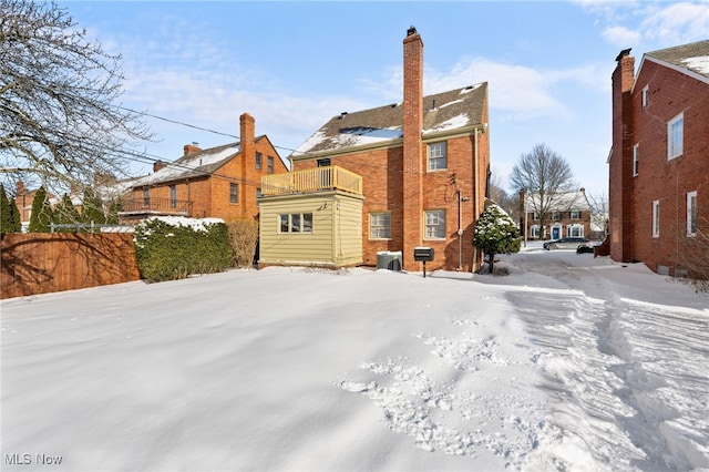 snow covered property with a balcony and central air condition unit