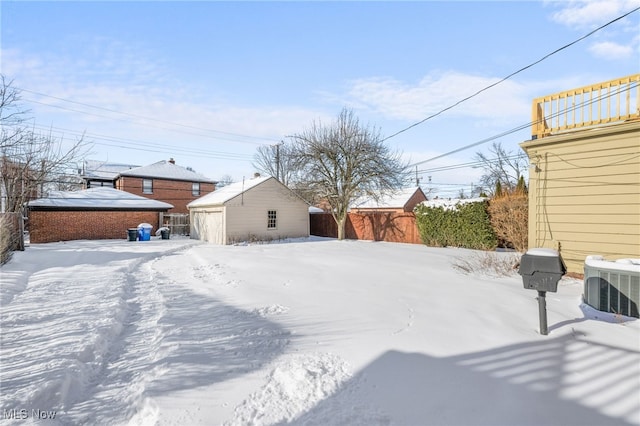 snowy yard featuring a balcony and an outdoor structure