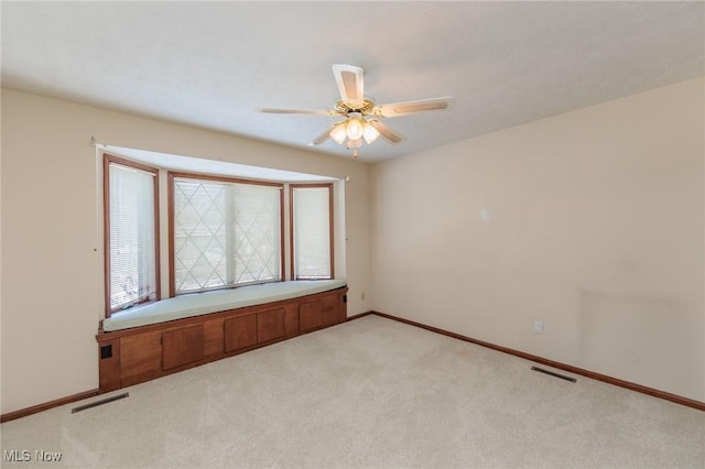 carpeted spare room featuring ceiling fan