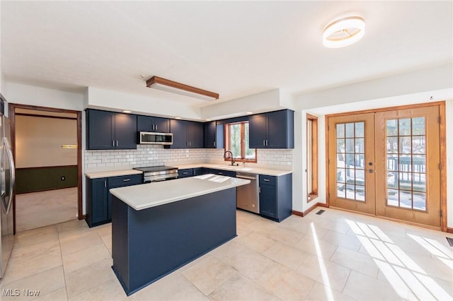 kitchen with a kitchen island, appliances with stainless steel finishes, blue cabinetry, and french doors