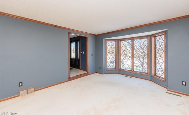 empty room featuring ornamental molding and carpet