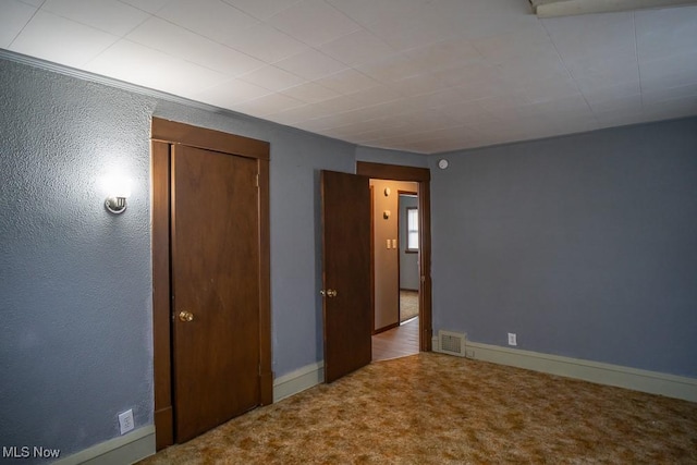 unfurnished bedroom featuring a closet and carpet flooring