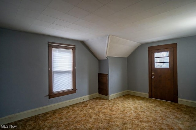 bonus room with lofted ceiling and carpet floors