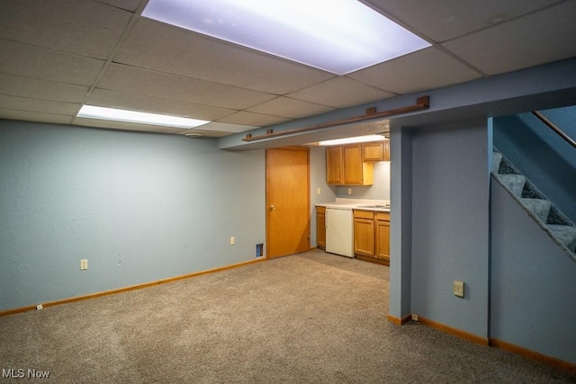 basement with a drop ceiling and light carpet