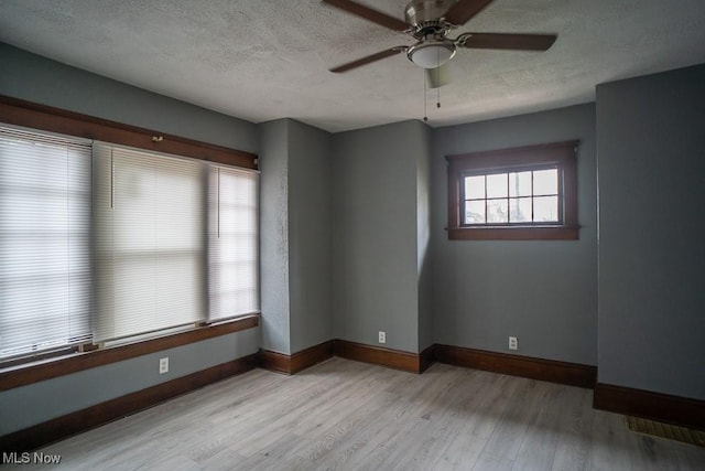 unfurnished room featuring ceiling fan, a textured ceiling, and light wood-type flooring