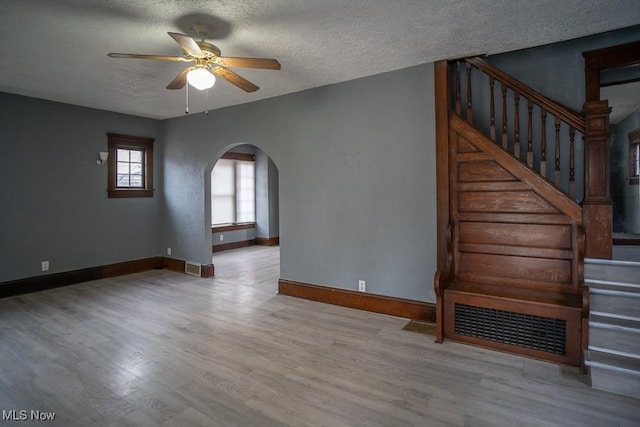 spare room with ceiling fan, light hardwood / wood-style floors, and a textured ceiling