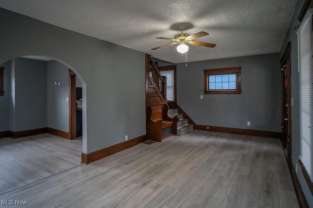 spare room featuring ceiling fan, light hardwood / wood-style flooring, and a textured ceiling