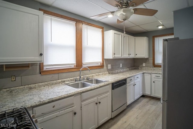 kitchen with sink, appliances with stainless steel finishes, backsplash, light hardwood / wood-style floors, and white cabinets