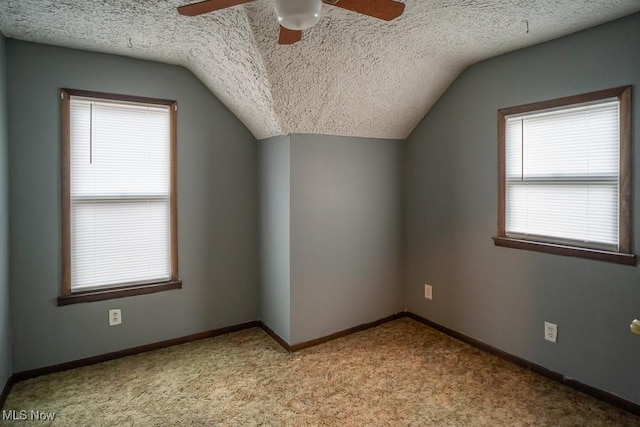 additional living space featuring ceiling fan, lofted ceiling, light carpet, and a textured ceiling