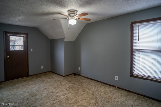 bonus room featuring light carpet, ceiling fan, vaulted ceiling, and a textured ceiling