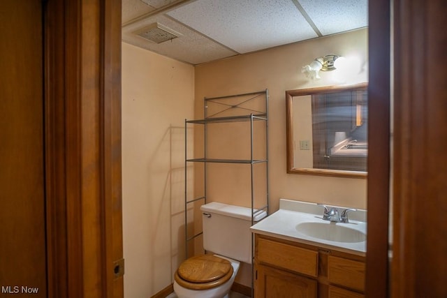 bathroom with vanity, a paneled ceiling, and toilet