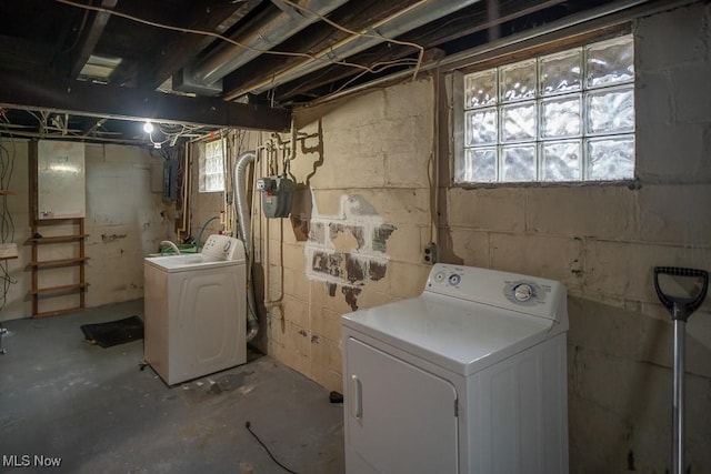 clothes washing area with washer and clothes dryer and electric panel