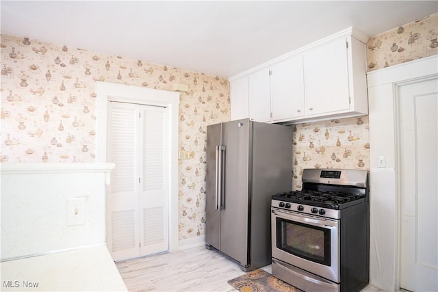 kitchen featuring stainless steel appliances, white cabinets, and light hardwood / wood-style flooring