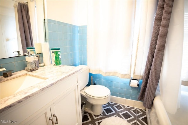 full bathroom with vanity, tile walls, shower / bath combination with curtain, and toilet