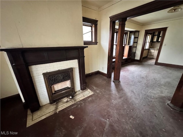 unfurnished living room featuring a fireplace and ornate columns