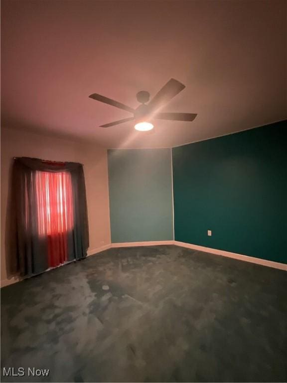 spare room featuring ceiling fan and carpet