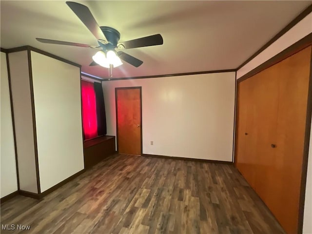 unfurnished bedroom featuring ornamental molding, dark hardwood / wood-style floors, ceiling fan, and a closet