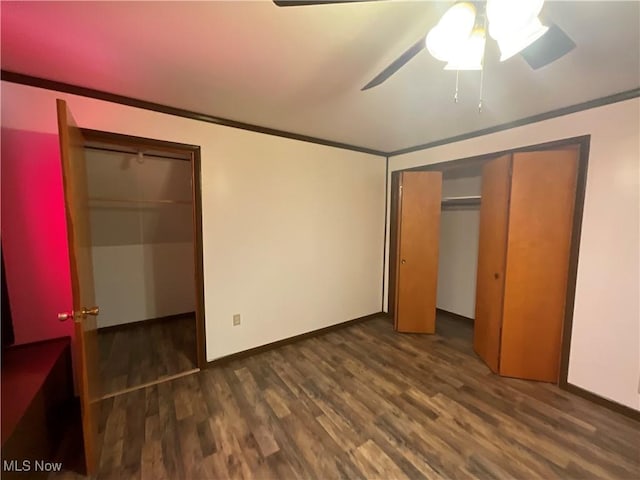 unfurnished bedroom with crown molding, dark wood-type flooring, and ceiling fan