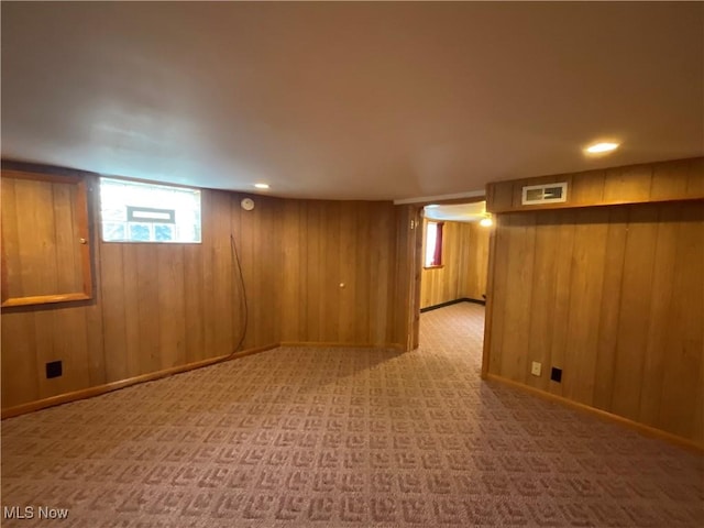 basement featuring carpet flooring and wood walls