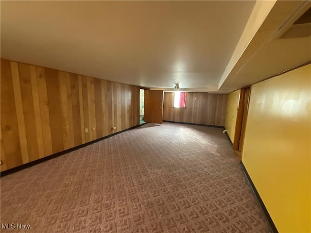 interior space with dark carpet and wood walls