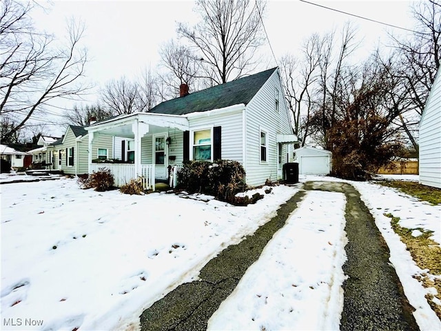 view of front of property featuring an outbuilding, a garage, and a porch