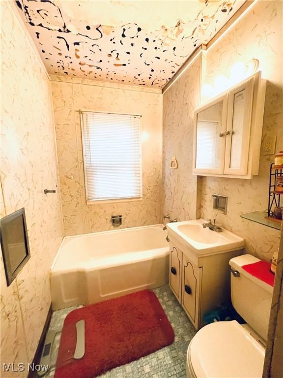 bathroom featuring vanity, toilet, and a washtub