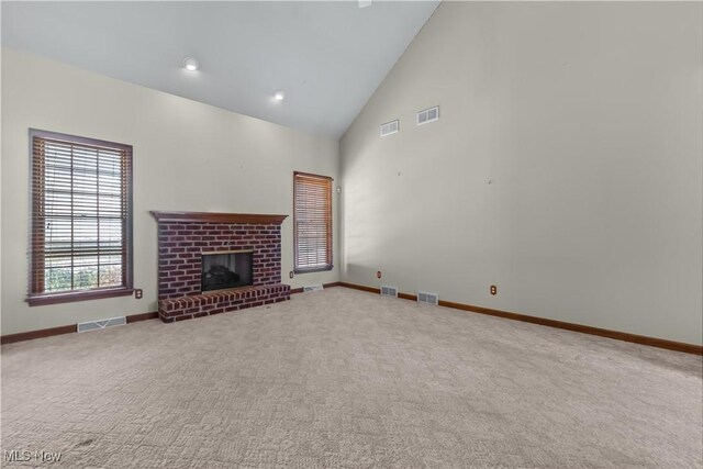 unfurnished living room featuring carpet flooring, a fireplace, and high vaulted ceiling